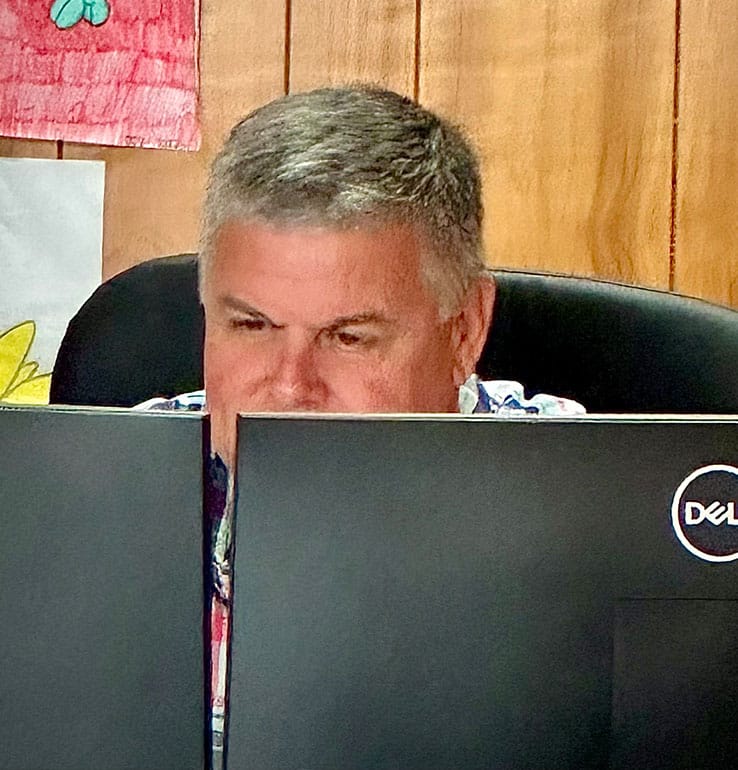 a man sitting in front of a laptop